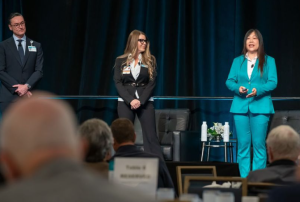 3 people on stage presenting