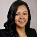 Woman with dark hair and dark jacket posing for headshot