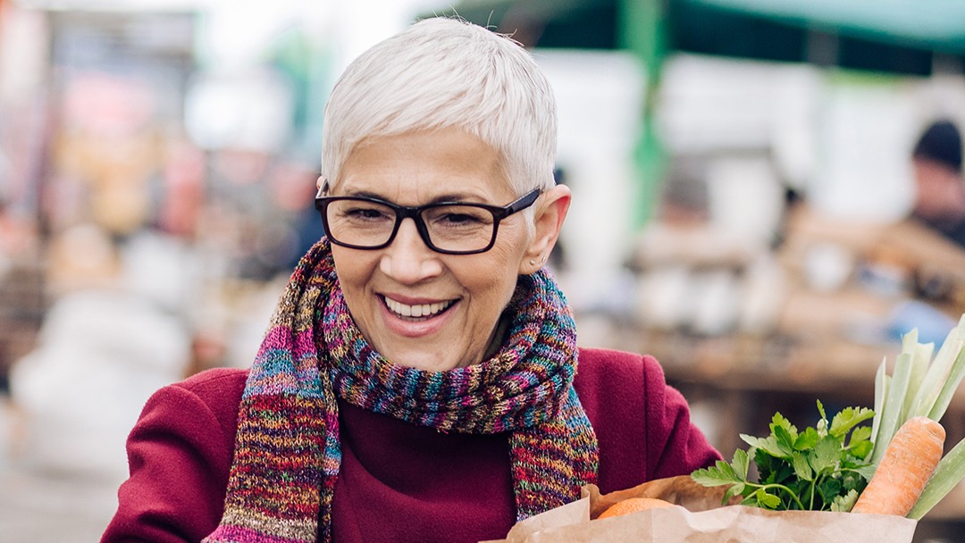 Woman with scarf and grocery bag shopping